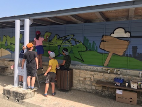 Enfants qui créent leur fresque en graff sous l'abribus